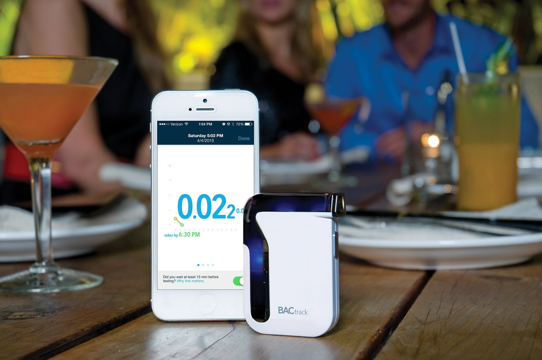 BACtrack Mobile breathalyzer on a table with drinks